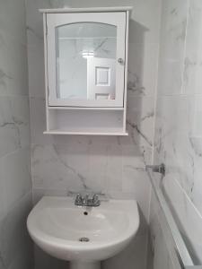 Bella Blus Villa的一间白色浴室，配有洗手池和镜子。