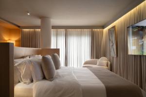 a bedroom with a large white bed and a window at Íz Hotel Conceito in Goiânia +16 photos