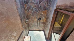 uma casa de banho com um chuveiro numa parede de pedra em Hotel Toconar em San Pedro de Atacama