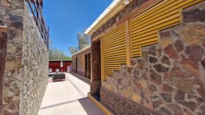 uma vista exterior de um edifício com uma parede de pedra em Hotel Toconar em San Pedro de Atacama