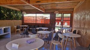 uma fileira de mesas e cadeiras em uma sala com janelas em Hotel Toconar em San Pedro de Atacama