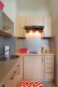 a kitchen with a stove, sink, and refrigerator at Apartamenty Media Park in Warsaw