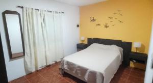 a bedroom with a bed and a window with birds on the wall at Casa con parque para 5 personas in Miramar