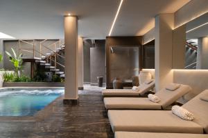 a hotel lobby with a pool and lounge chairs at Íz Hotel Conceito in Goiânia
