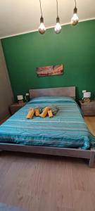 two people laying on a bed with a green wall at Re Di Coppe in Torre Boldone