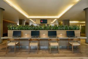 a lobby with a long counter with four computers on it at Fiesta Inn Monterrey Valle in Monterrey