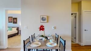uma mesa de jantar com um vaso de flores sobre ela em Stamford Cozy Apartment with free parking em Stamford