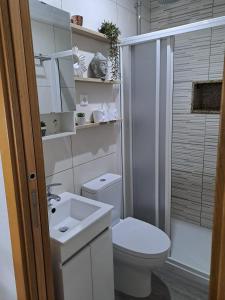 een witte badkamer met een toilet en een wastafel bij CriCastelo - Alojamento Local in Trancoso