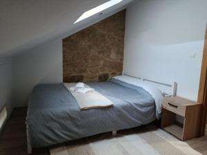 a bedroom with a bed with a towel on it at CriCastelo - Alojamento Local in Trancoso