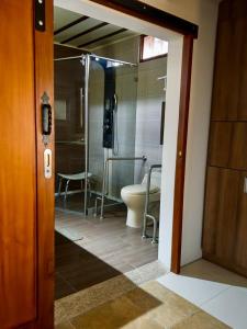 a bathroom with a toilet and a glass door at Casa Chute in Chinchiná