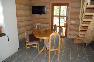 ein Esszimmer mit einem Holztisch und Stühlen in der Unterkunft Naturstamm Ferienhaus in Trassenheide