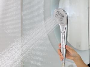 a person holding a shower brush in front of a window at APA Hotel Asakusa Kuramae in Tokyo