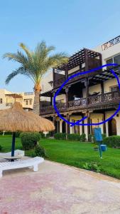 a building with a palm tree and a blue ribbon at Family Holiday 2 Bedroom Chalet with free Beach & Pool in Sharm, Egypt in Sharm El Sheikh