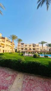 a park with palm trees in front of a building at Family Holiday 2 Bedroom Chalet with free Beach & Pool in Sharm, Egypt in Sharm El Sheikh