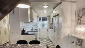 a kitchen with white cabinets and a table and chairs at Rymligt och härligt radhus i Göteborg in Gothenburg