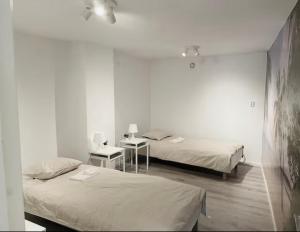 two beds in a room with white walls and wooden floors at Rymligt och härligt radhus i Göteborg in Gothenburg