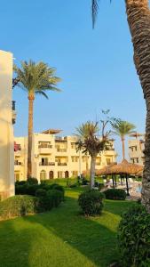 a resort with palm trees and a building at Family Holiday 2 Bedroom Chalet with free Beach & Pool in Sharm, Egypt in Sharm El Sheikh