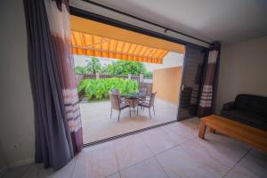 Zimmer mit einer Glasschiebetür mit einem Tisch und Stühlen in der Unterkunft Feri Lodge 3 in Tohautu