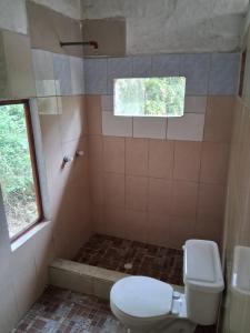 een badkamer met een toilet en een douche met een raam bij La Loma in Bellavista
