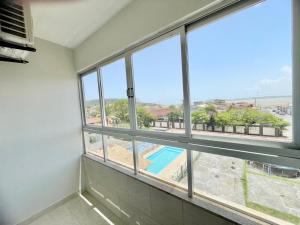 een kamer met ramen met uitzicht op een zwembad bij Pousada Shalom Adonai-1 in Guarapari