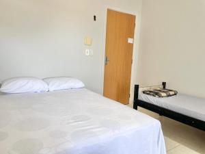 een slaapkamer met twee bedden en een houten deur bij Pousada Shalom Adonai-1 in Guarapari