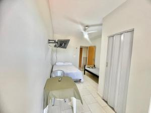 een slaapkamer met een bed en een tafel in een kamer bij Pousada Shalom Adonai-1 in Guarapari