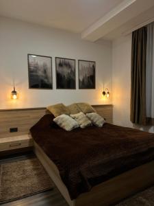 a bedroom with a bed with three pillows on it at Mountain Hearth - Milmari Resort in Kopaonik +45 photos