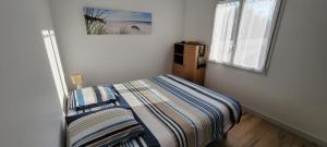 een kleine slaapkamer met een bed en een raam bij La maison du saule in Yves