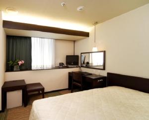 a hotel room with a bed and a desk at Niigata City Hotel in Niigata
