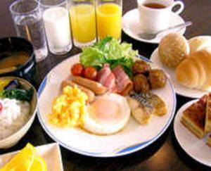 a table topped with plates of breakfast foods and drinks at Niigata City Hotel in Niigata