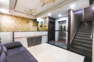 a living room with a staircase and a couch at Hotel Mini Escape Perungalathur in Chennai