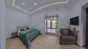 a bedroom with a bed and a couch and a tv at Luxury Home Airport in Naples