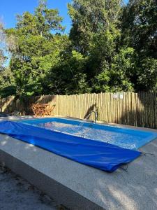 een zwembad met een blauw zeil ernaast, naast een hek bij Casa para Veraneio - Sargi in Uruçuca
