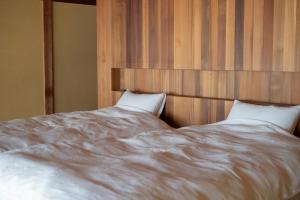 a large white bed with two pillows on it at 久乃家 in Matsue