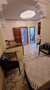 a living room with a bed and a chandelier at Appartement lumineux 2 pas à l'aéroport in Marrakech