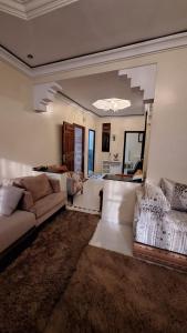 a living room with a couch and a table at Appartement lumineux 2 pas à l'aéroport in Marrakech