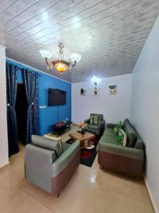 a living room with two couches and a tv at Maison meublée VERTE in Yaoundé