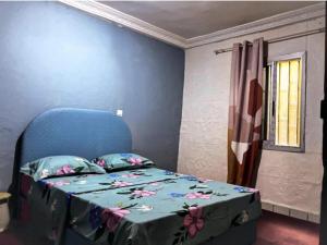 a bedroom with a blue bed with a blue head board at Maison meublée VERTE in Yaoundé