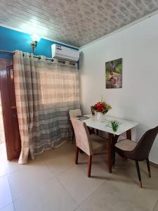 a dining room with a table and chairs at Maison meublée VERTE in Yaoundé