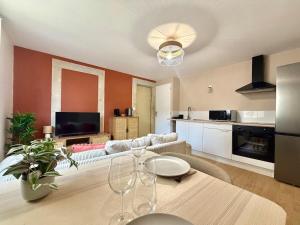 ein Wohnzimmer mit Tisch und Küche in der Unterkunft Le chateau d'Altheis in Dole