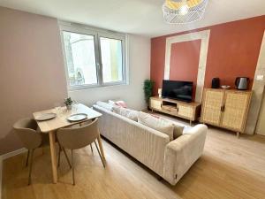 ein Wohnzimmer mit Sofa und Tisch in der Unterkunft Le chateau d'Altheis in Dole