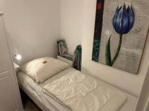 un piccolo letto in una stanza con un dipinto sul muro di Relax 2 a Goslar