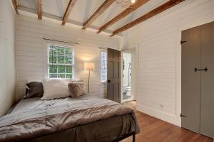 ein Schlafzimmer mit einem Bett in einem Zimmer mit weißen Wänden in der Unterkunft 4 Blocks from King Street, Classic, Cool, Quiet in Charleston