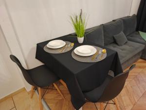un tavolo nero con due sedie e un divano di Perfekt Place a Oświęcim Altre 3 foto