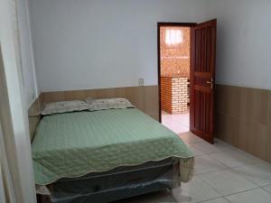 a bedroom with a bed with a green comforter at AP Morro Branco in Beberibe