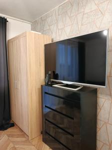 una grande TV a schermo piatto seduta sopra un comò di Perfekt Place a Oświęcim