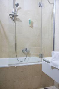 een badkamer met een douche met een glazen deur bij Rooms Blanc in Pučišća