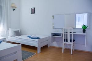 een slaapkamer met een bed, een bureau en een stoel bij Rooms Blanc in Pučišća +105 foto's