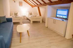 a living room with a couch and a table and a tv at Rooms Bed and Breakfast Blanc in Pučišća