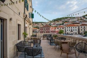 an outdoor patio with tables and chairs and a city at Rooms Bed and Breakfast Blanc in Pučišća